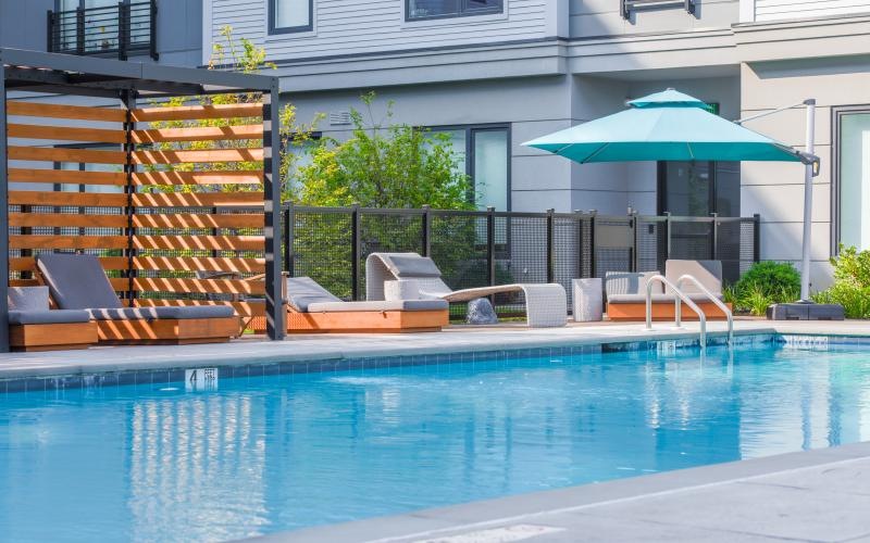 a pool with chairs and umbrella