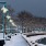 a snowy park with street lights and trees